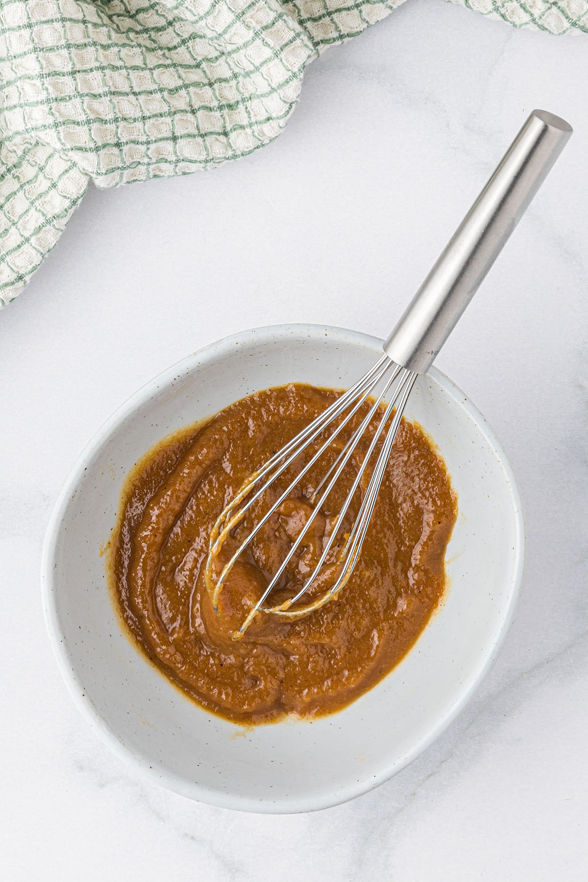 apple butter glaze for pork chops in a bowl with a whisk