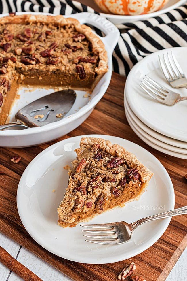 slice of pie on a white plate with a fork next to the whole pie