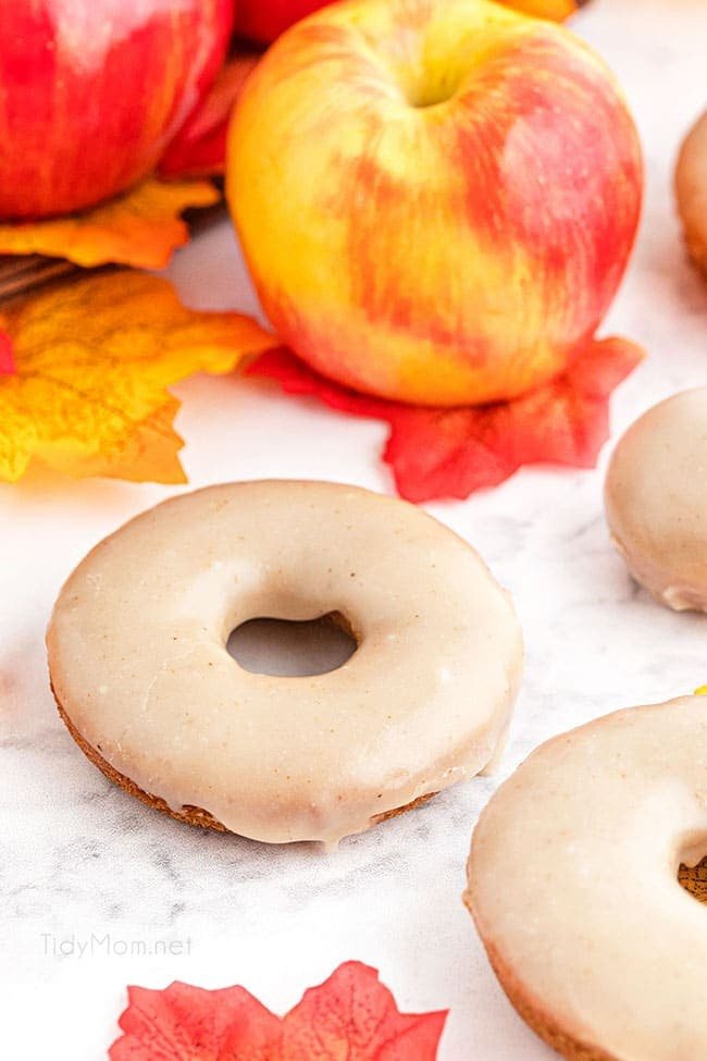apple cider donuts with a basket of apples and fall leaves