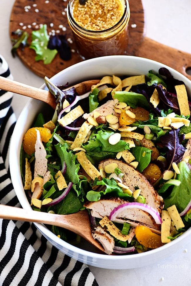 asian chicken salad in a bowl with salad spoons
