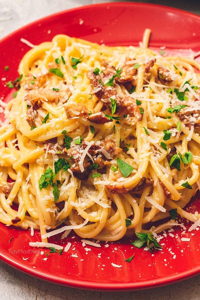 Easy and delicious classic Bacon Carbonara on a red plate