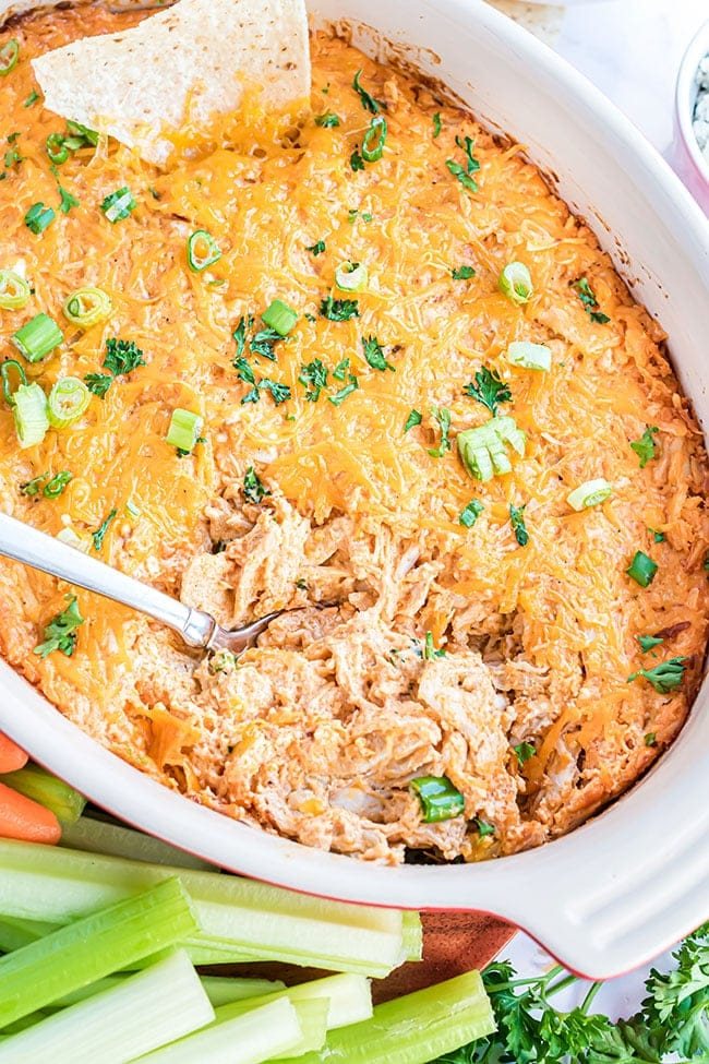 baked buffalo chicken dip in a white dish with a spoon