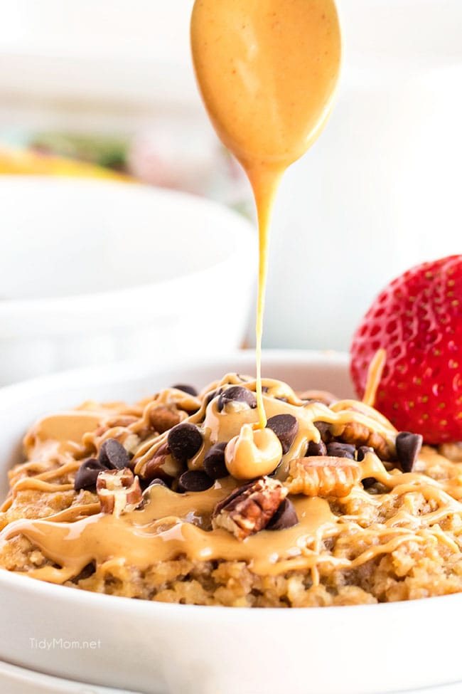 drizzling peanut butter over a bowl of baked oatmeal