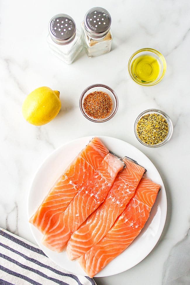 Fresh salmon on a plate with seasoning for baking in the oven
