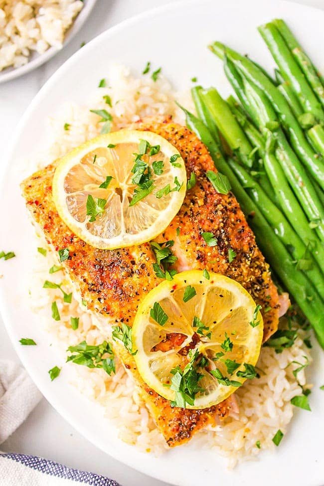 chili lime salmon on a plate with fresh lemon slices and steamed green beans