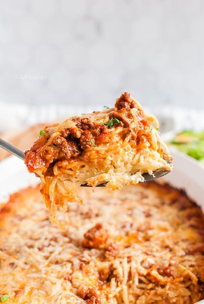 large serving spoonful of baked spaghetti