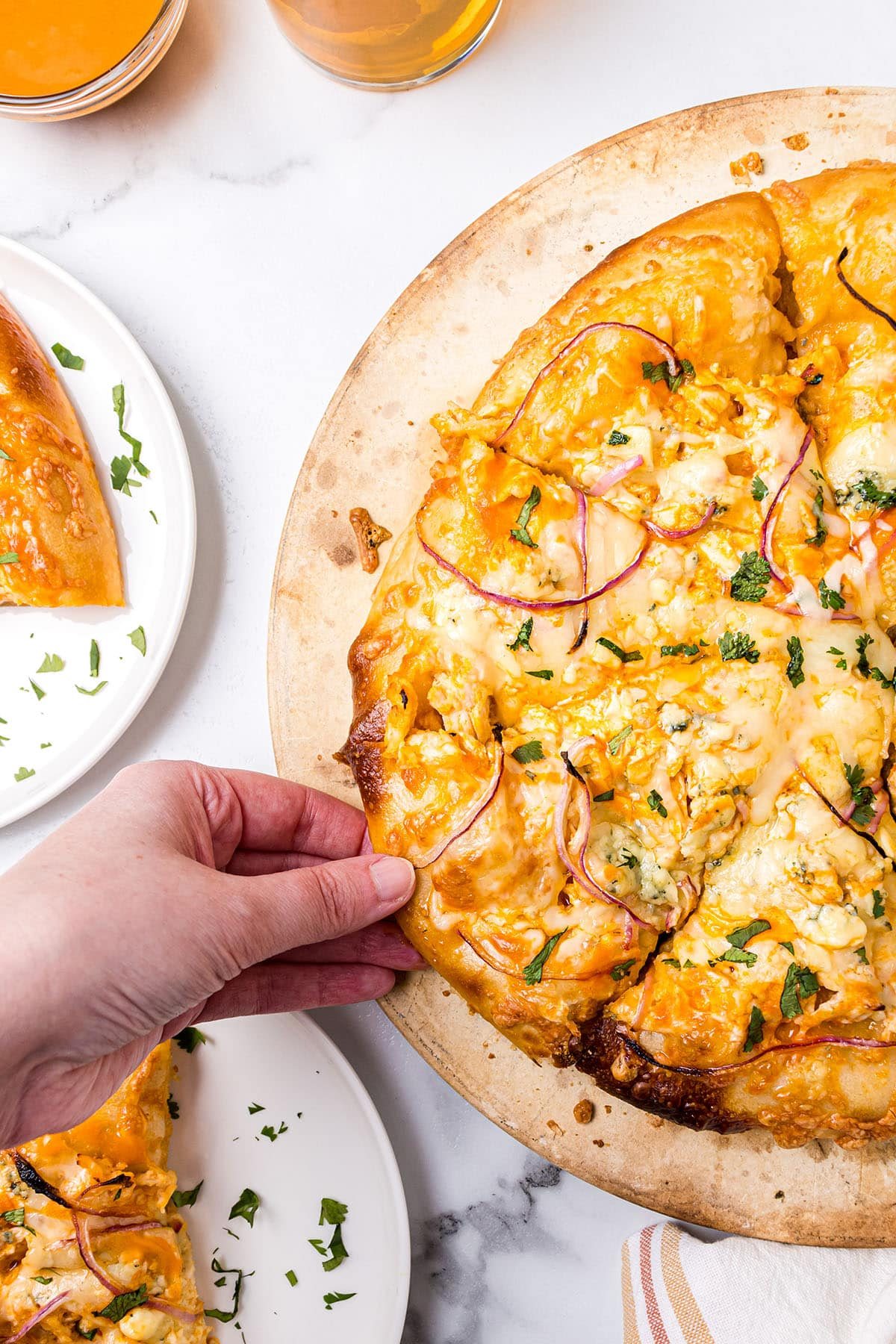 hand grabbing a slice of pizza