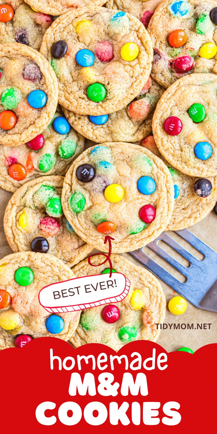 a pile of M&M cookies with a spatula