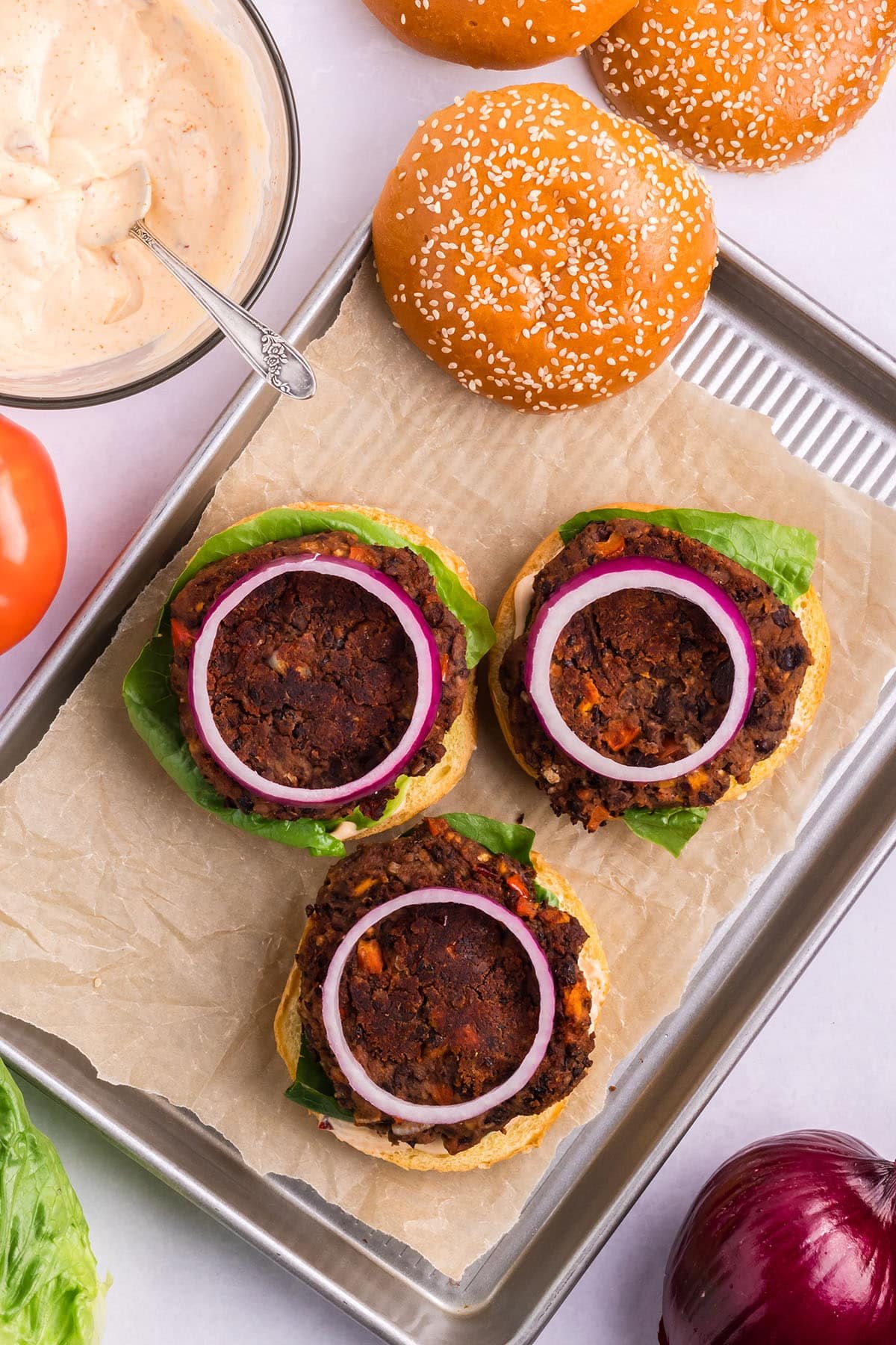 adding topping to burgers