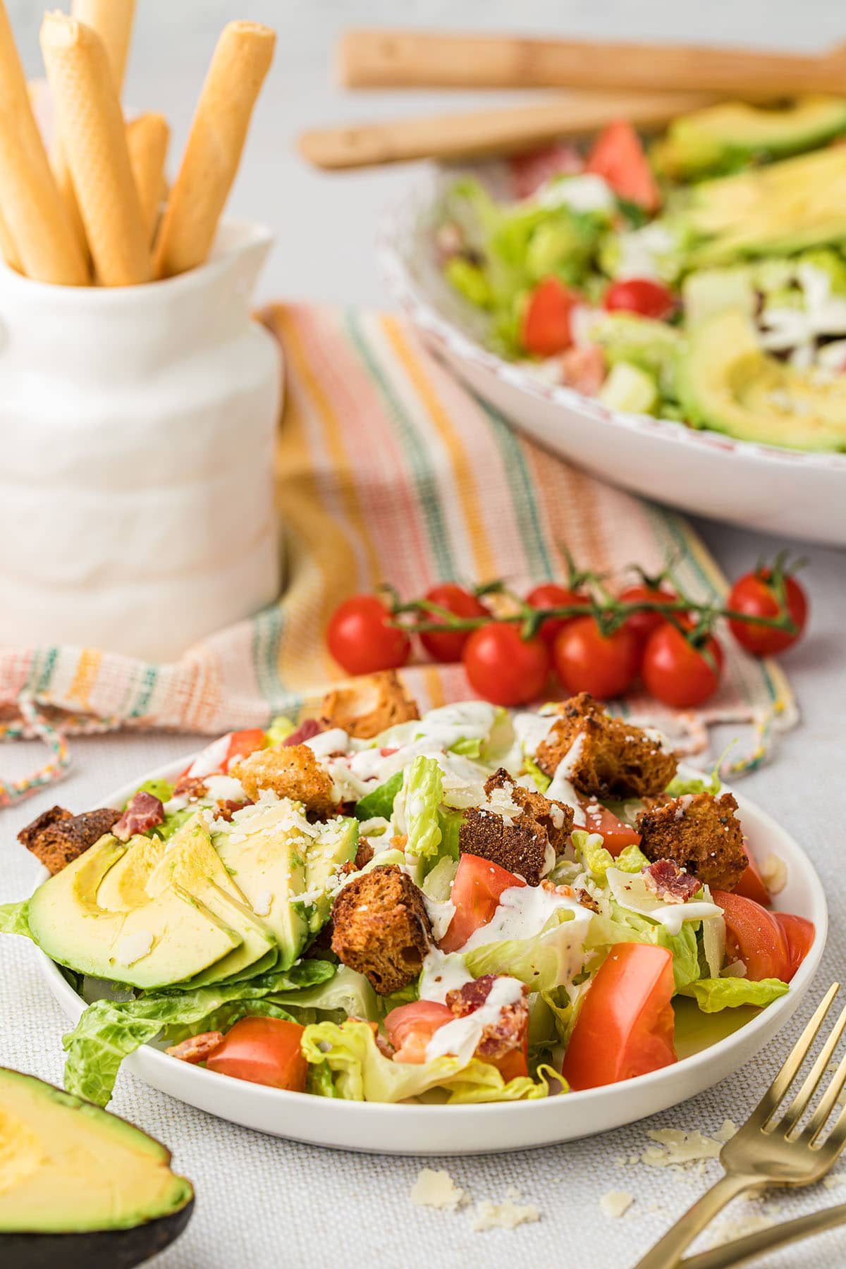 Fresh salad with bacon, lettuce and tomato on a white plate