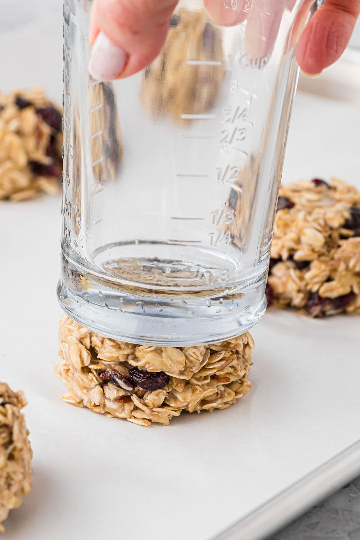 pressing a cookie with a glass bottom before cooking