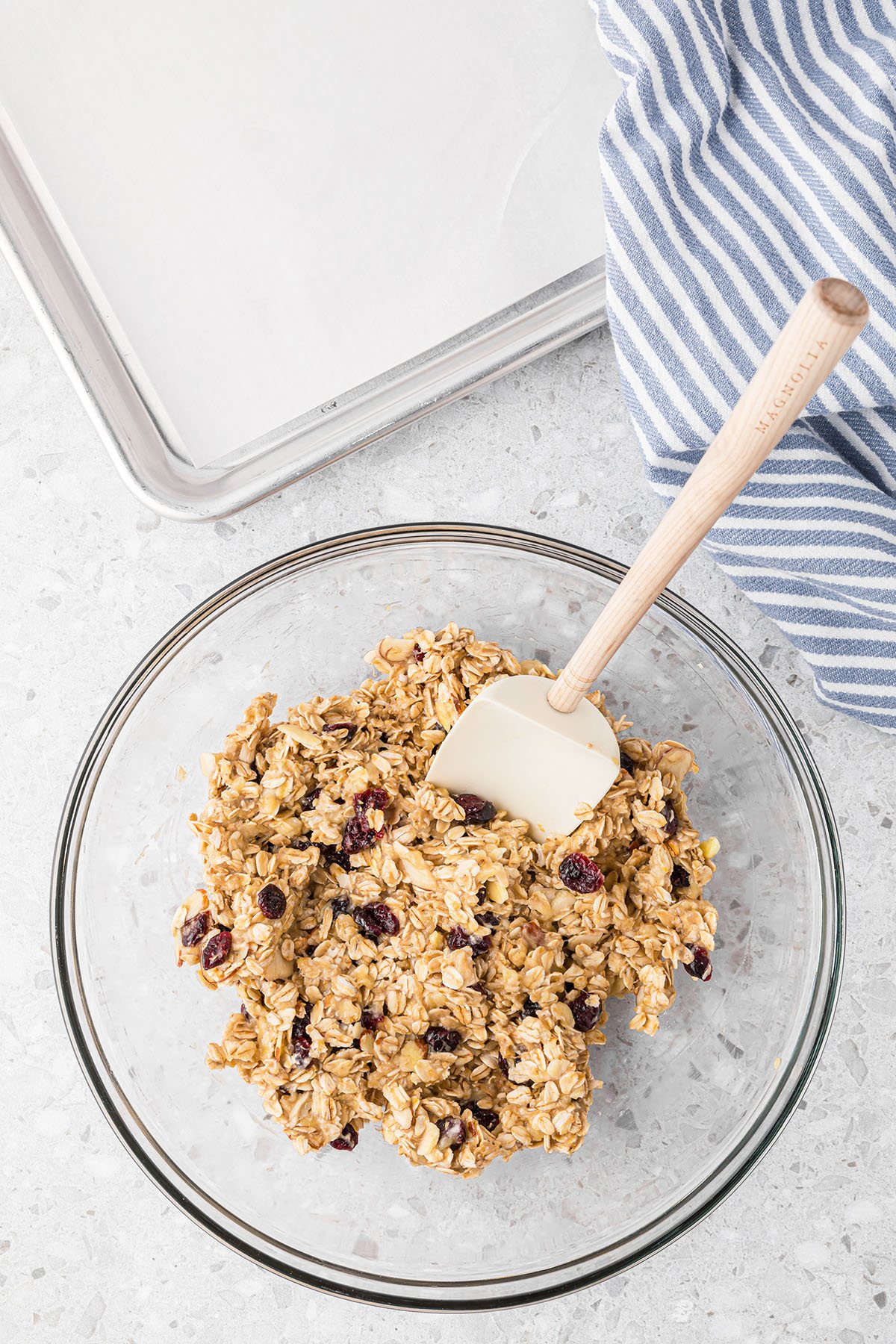 cookie dough in glass mixing bowl next to a baking sheet