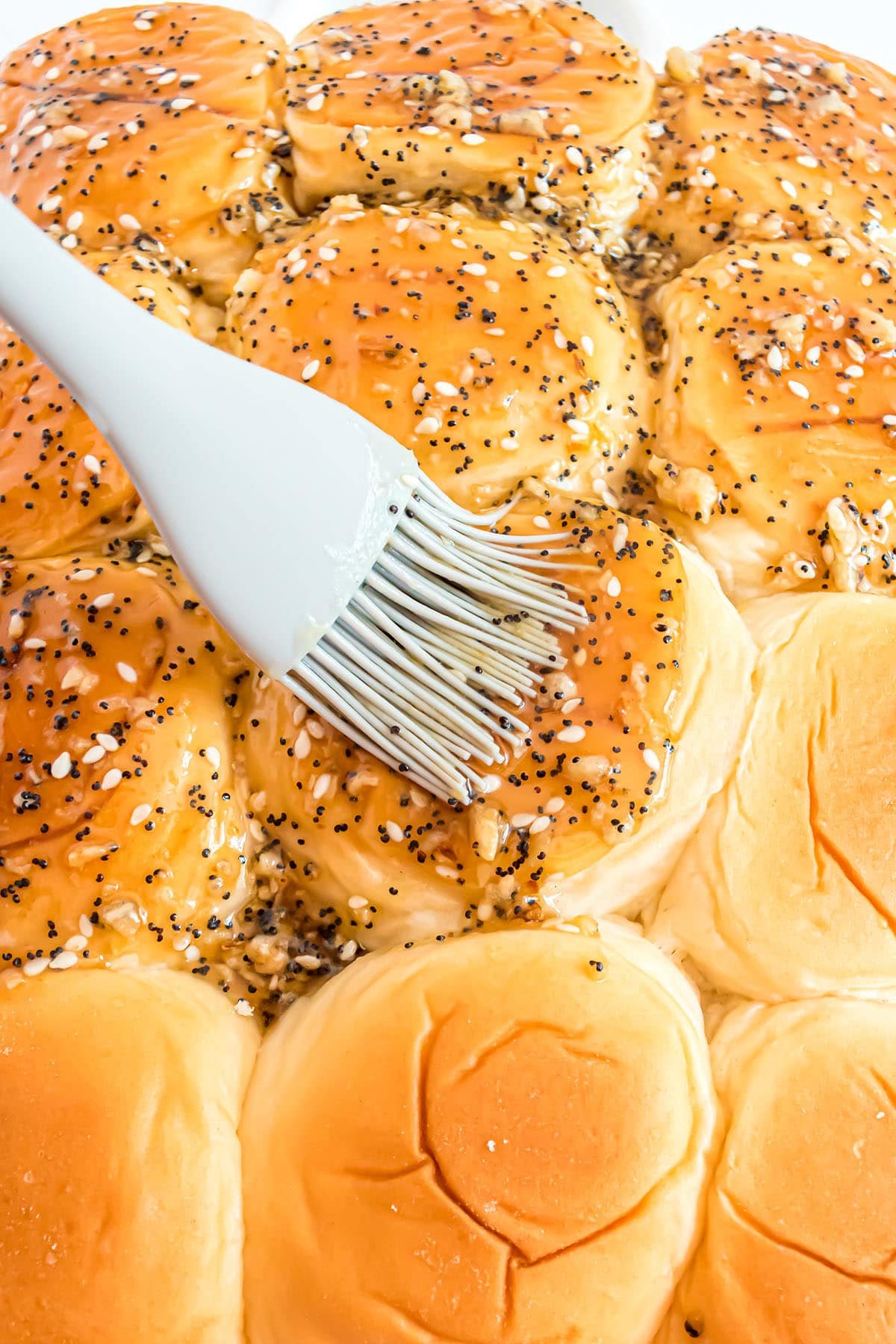 brushing seasoned melted butter on rolls