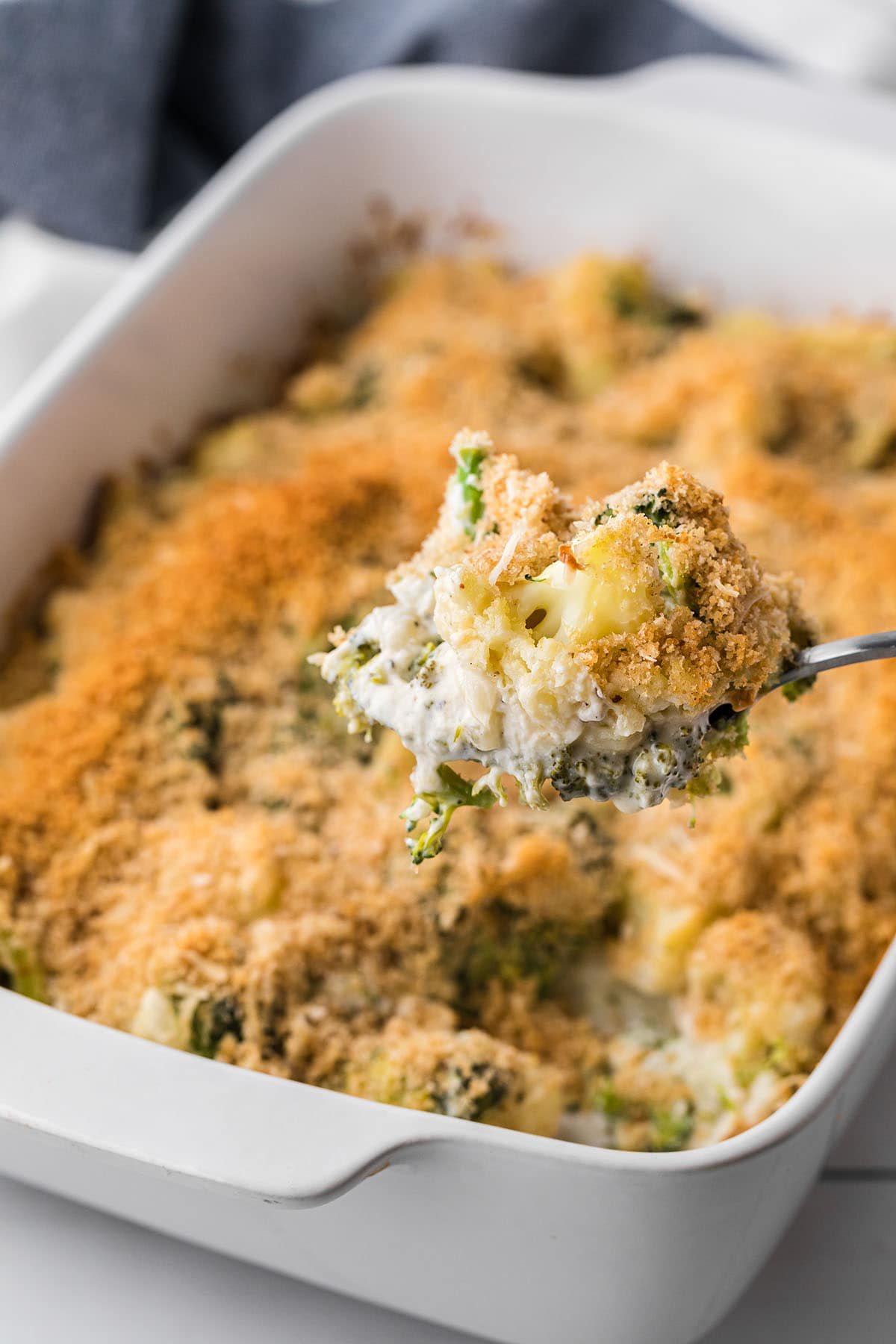Serving spoon with Cheesy Broccoli Cauliflower Casserole