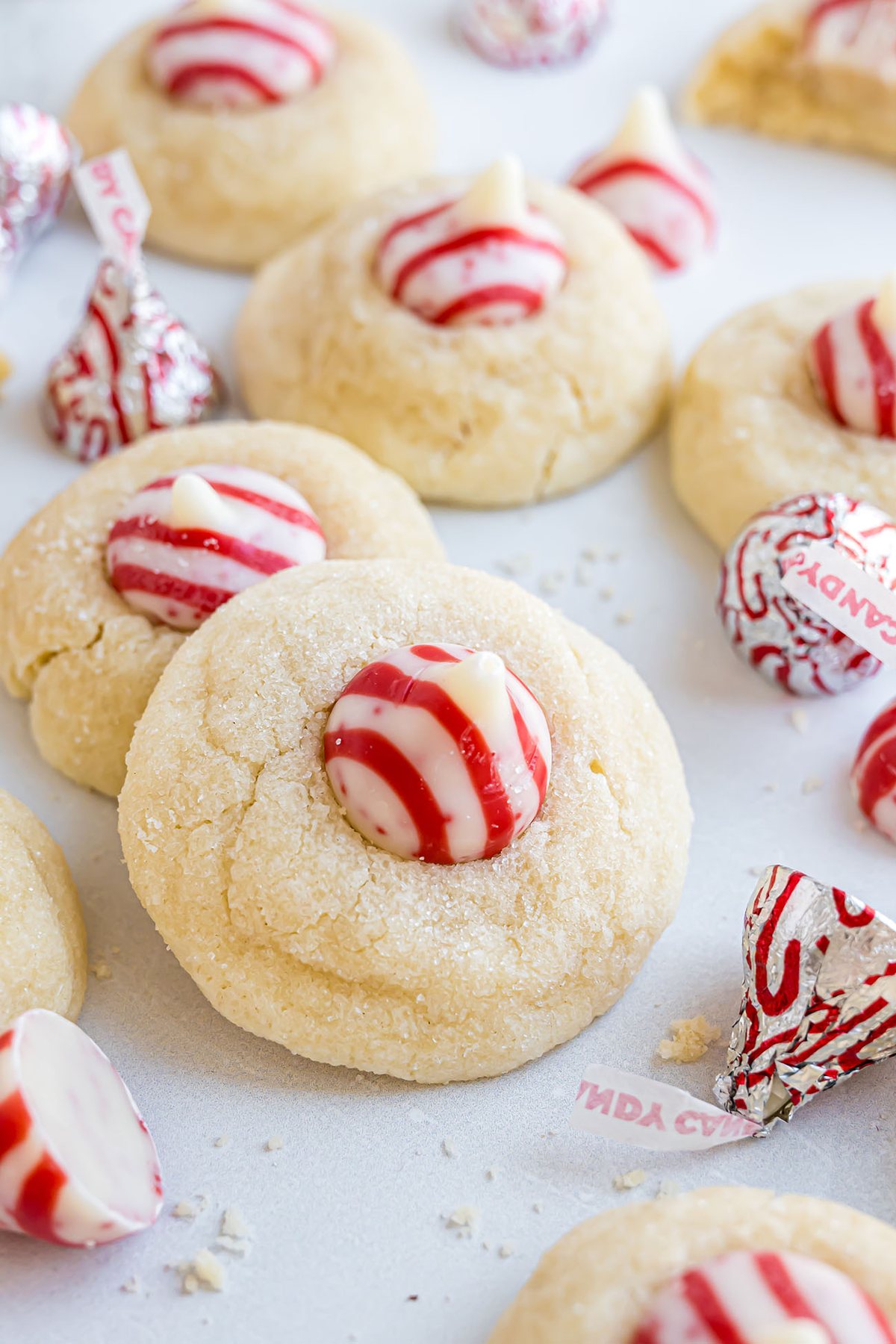 Holiday cookie pile featuring Candy Cane Kiss Cookies on a marble surface.