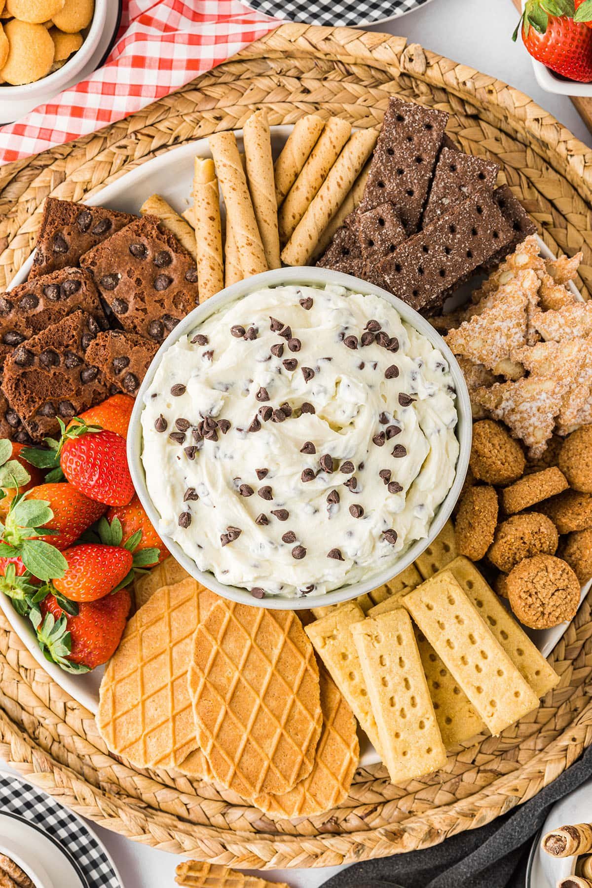 close up of cannoli dip dessert tray with cookies, fruit and broken waffle cones