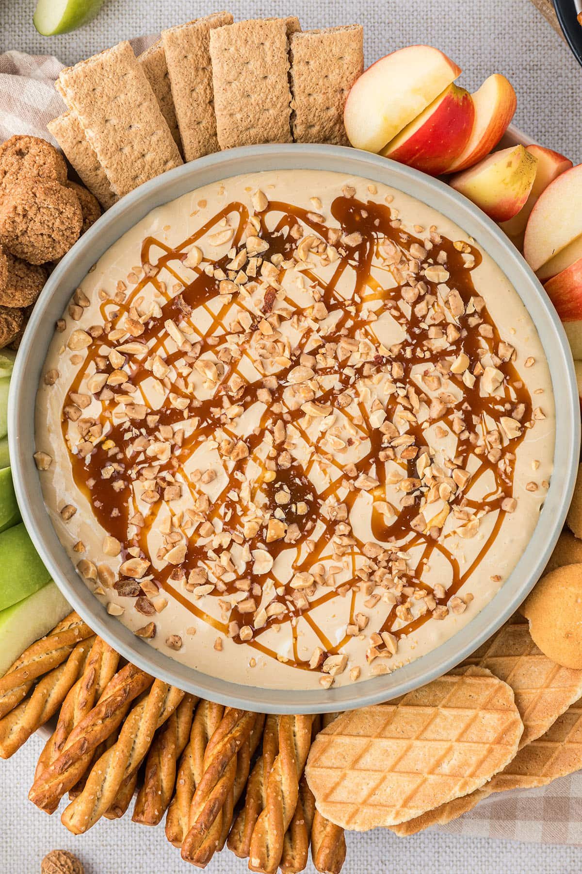 apple dip in a bowl with apple slices and other dippers around it