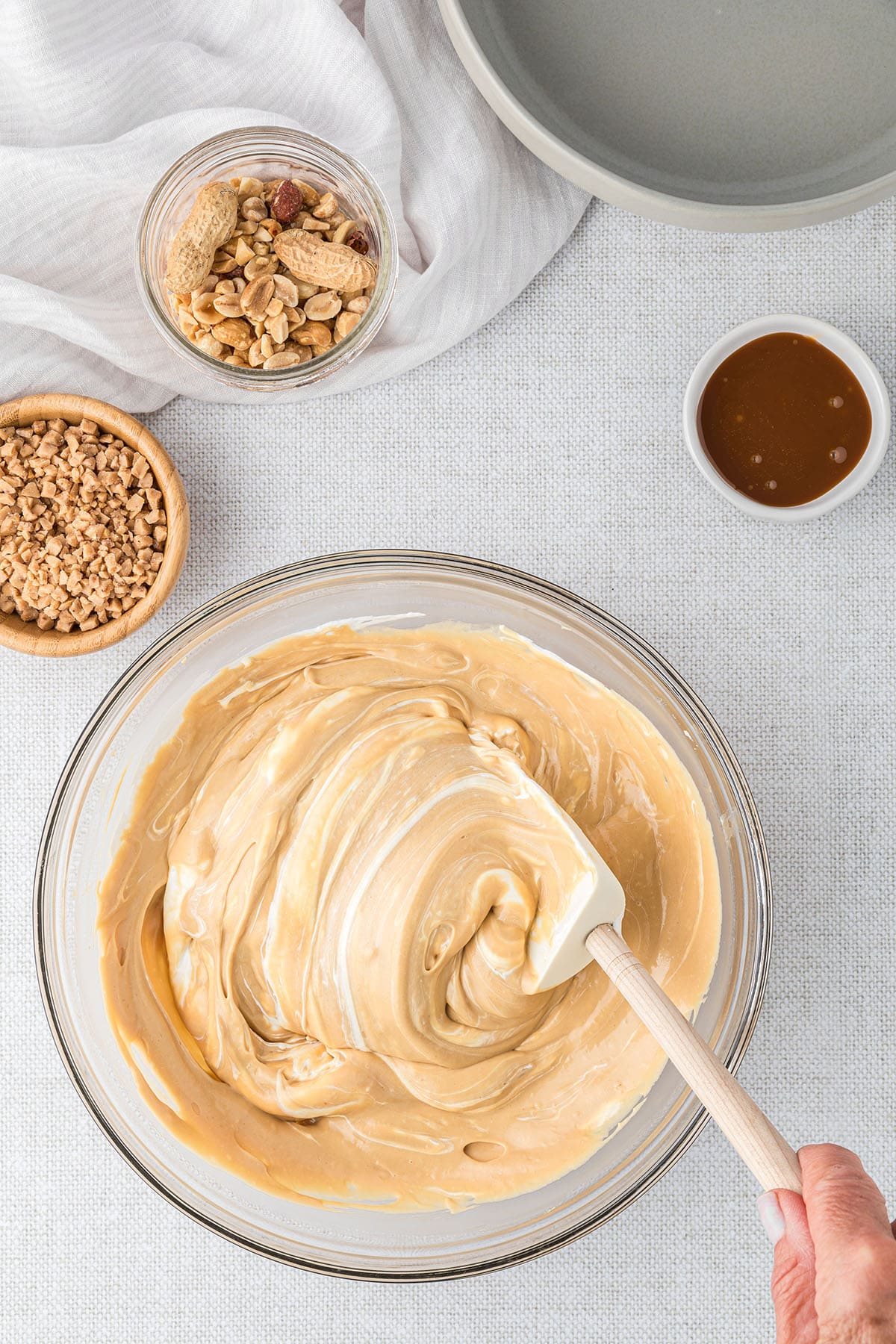 mixing a dessert dip in a glass bowl with a rubber spatula