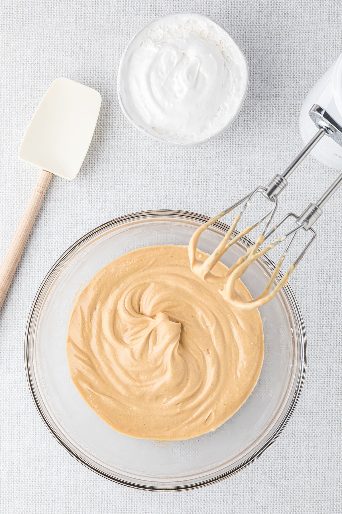 mixing up apple dip in a glass mixing bowl