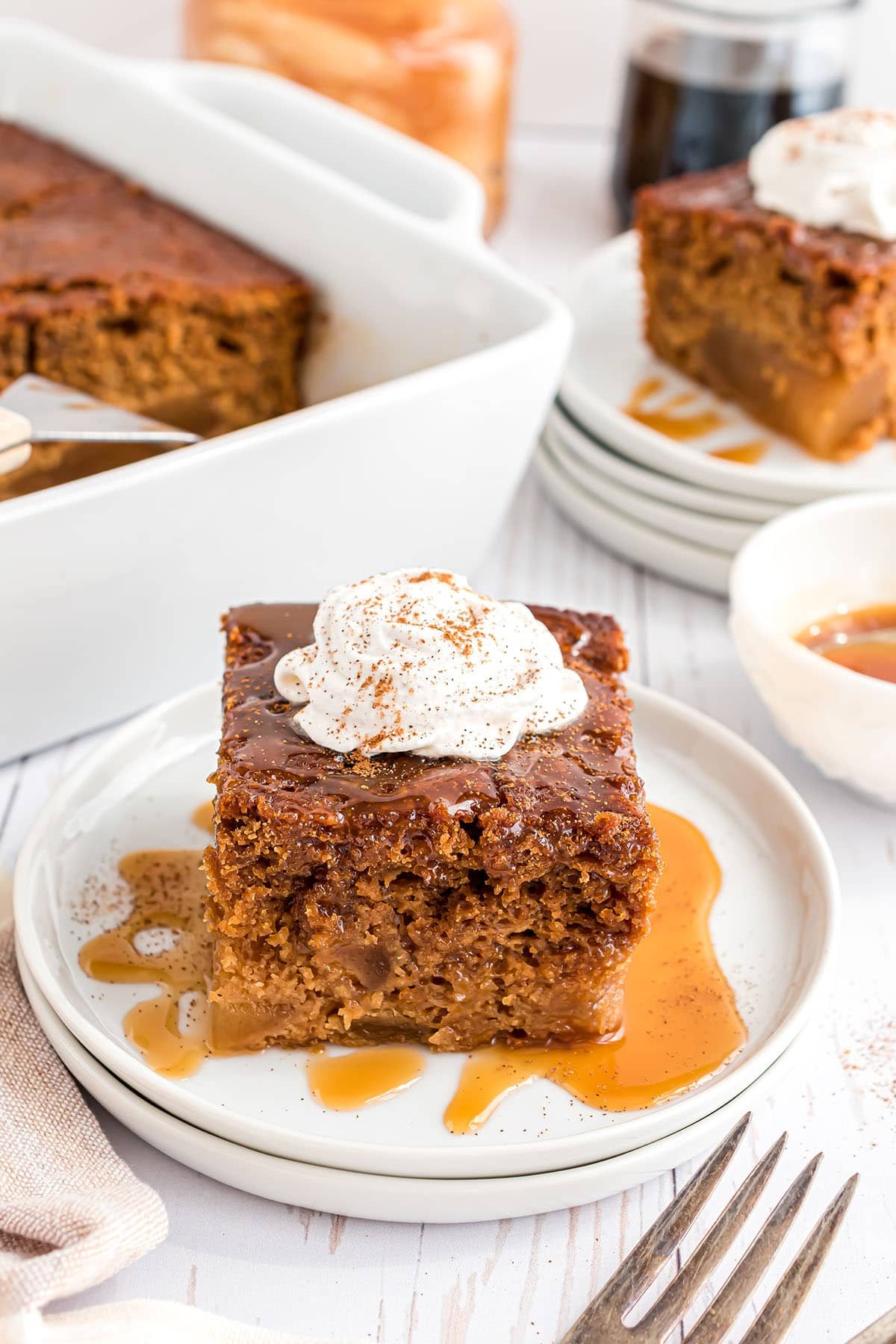 a piece of cake with whipped cream and caramel syrup