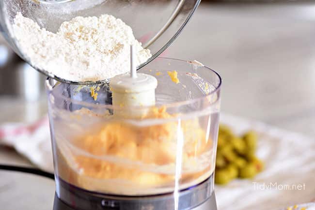 Cheesy Olive Bites: add flour to cheese and butter