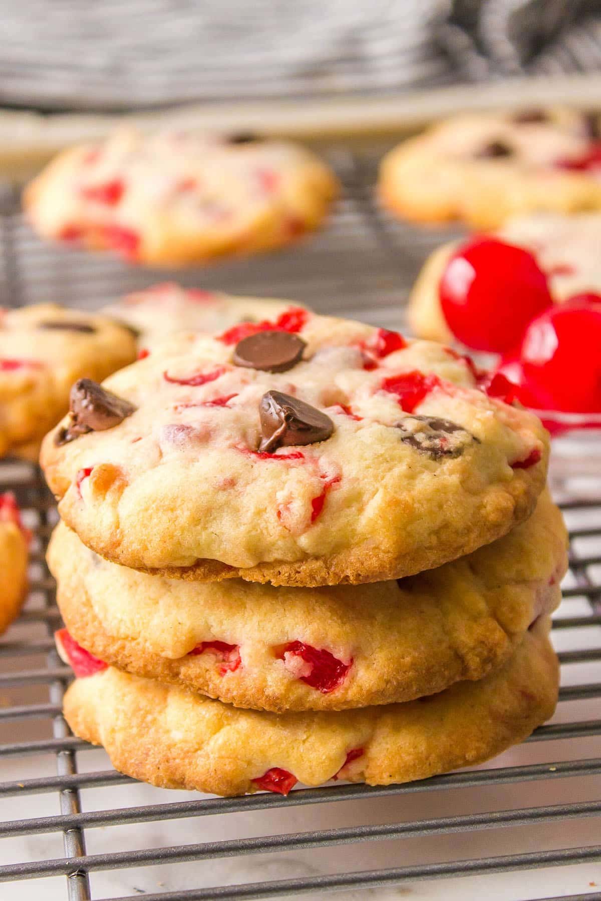 a stack of three chocolate chip cookies with maraschino cherries