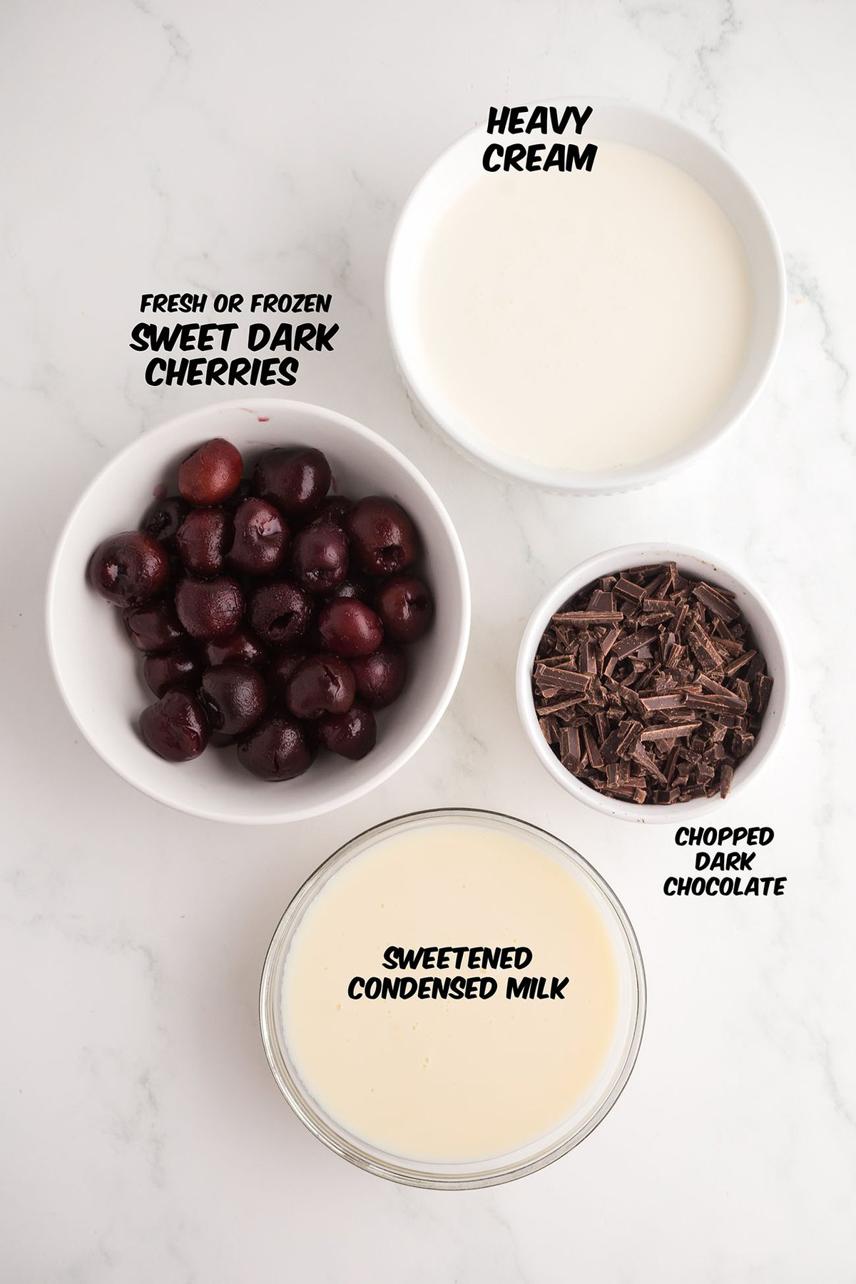 ingredients for no-churn Cherry Garcia ice cream including cherries, chocolate, heavy cream, and sweetened condensed milk