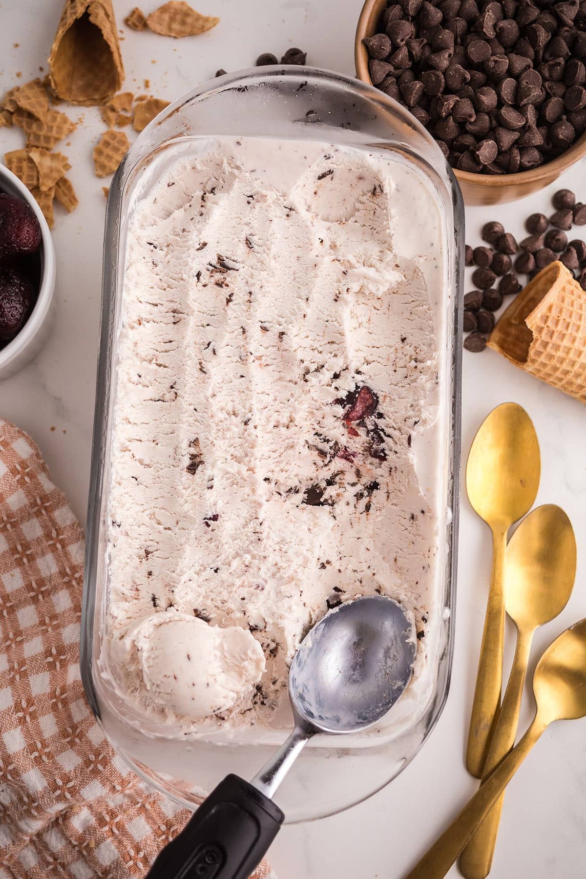 scooping homemade no-churn Cherry Garcia ice cream from loaf pan