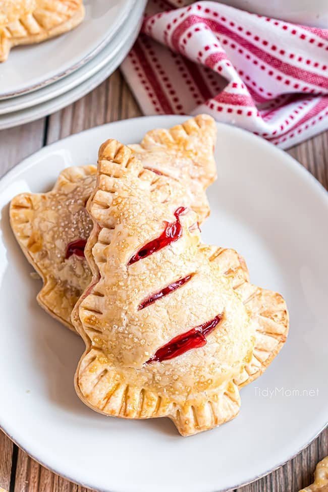 Two Christmas tree handheld cherry pies on a white plate