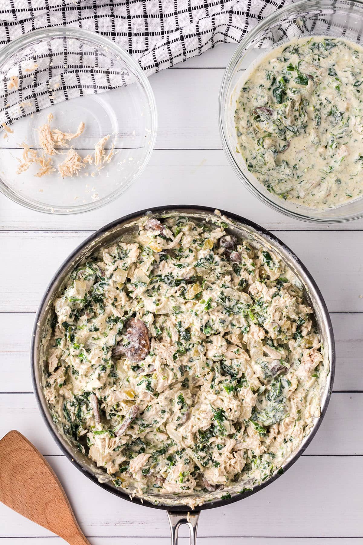 making white sauce with chicken and spinach in a skillet for enchilada casserole