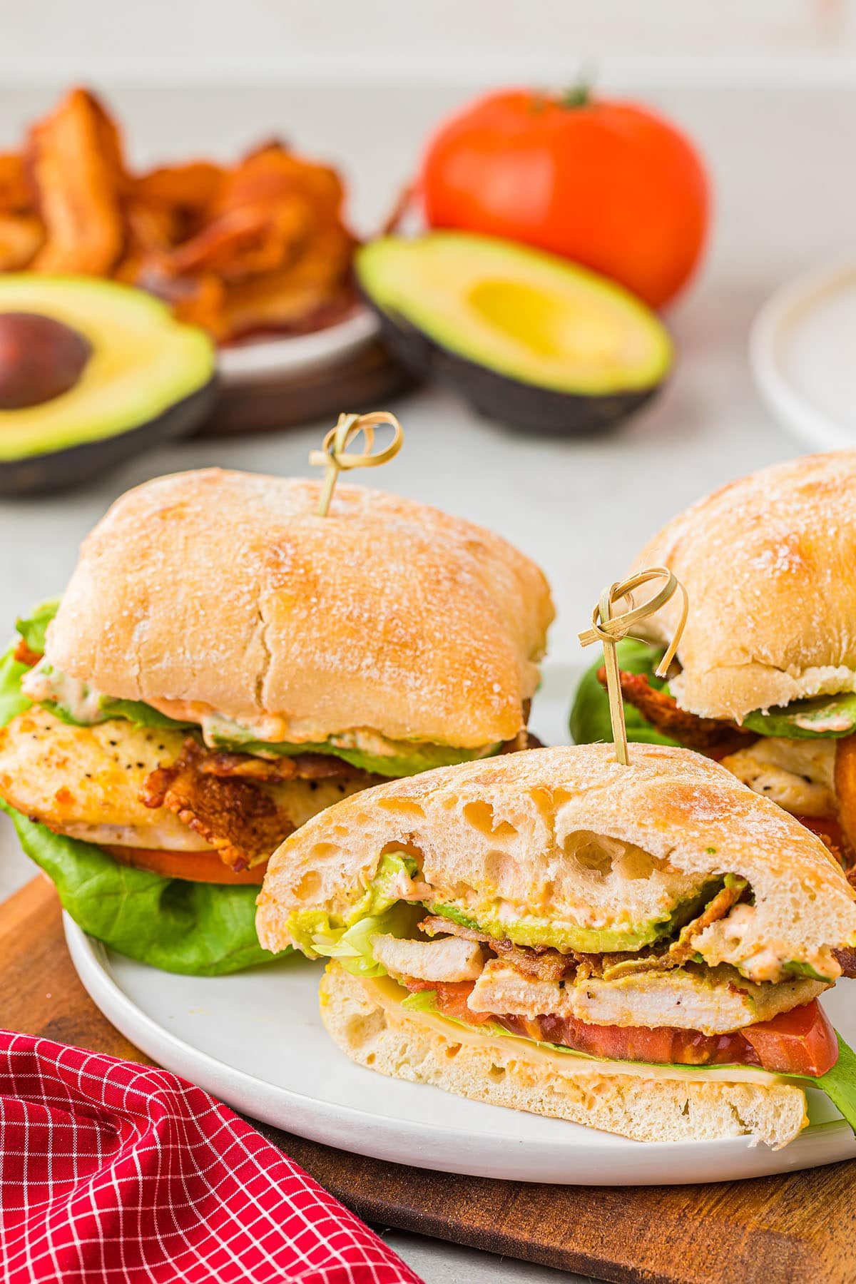 sandwiches on a plate with a red napkin in the foreground.