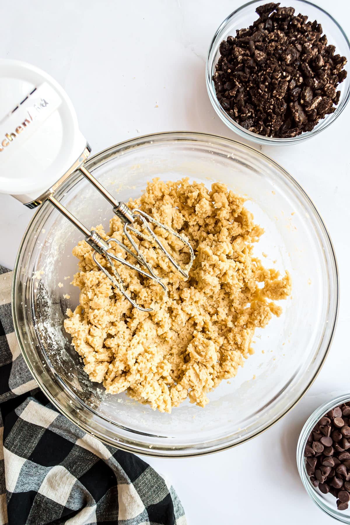 cookie dough in a clear mixing bowl with electric beaters