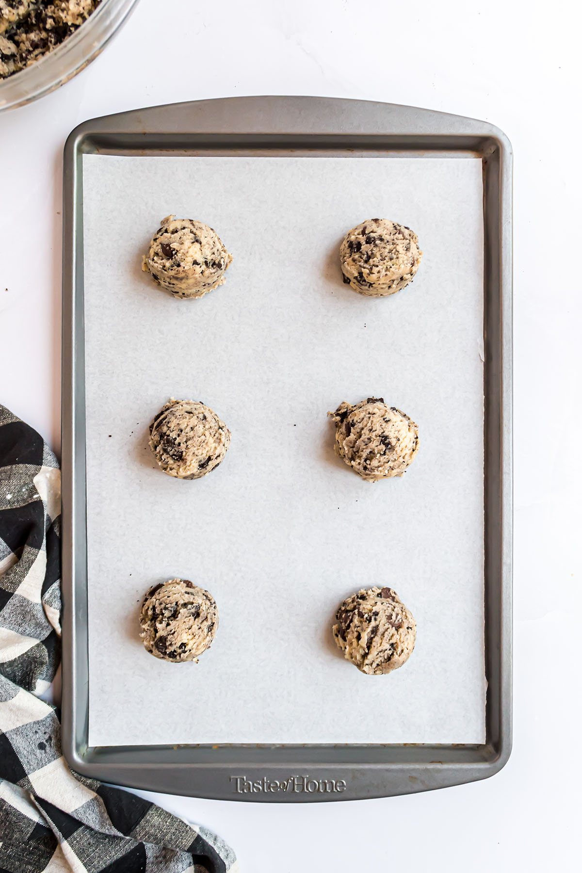 cookie dough balls on a parchment lined baking sheet