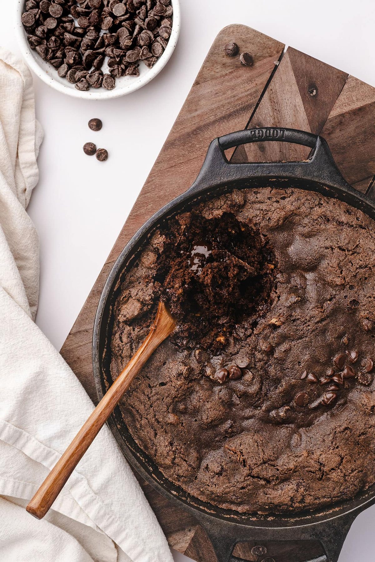 Wooden spoon resting in gooey chocolate cobbler