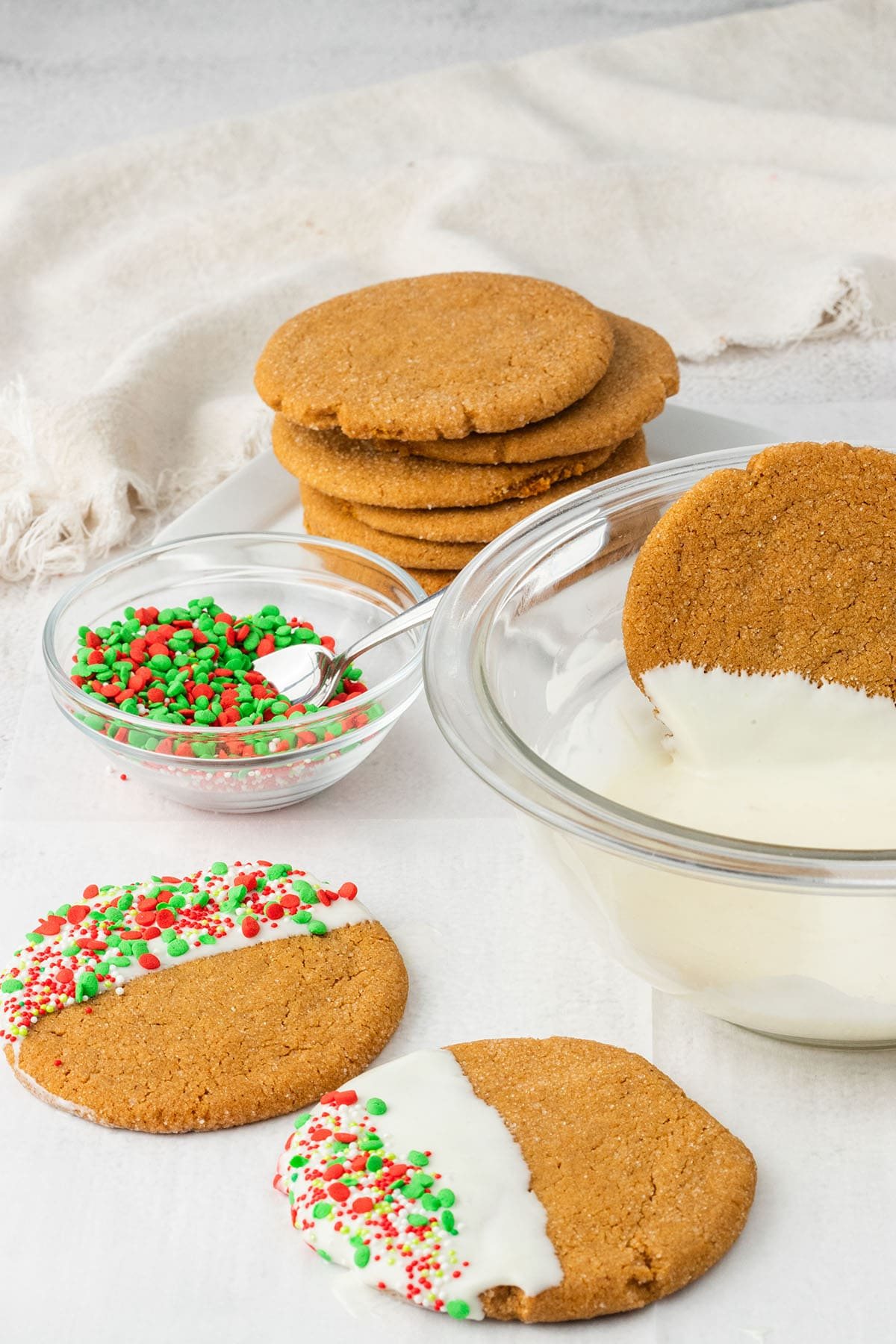 dipping ginger cookies in melted white chocolate and adding sprinkles