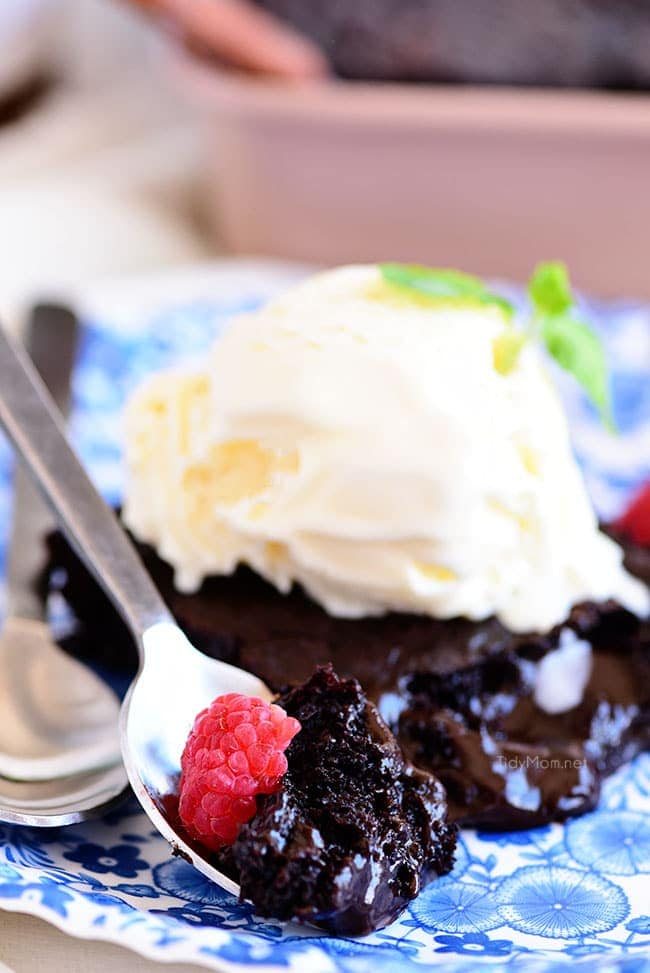 a bite of brownie cake on a plate topped with ice cream