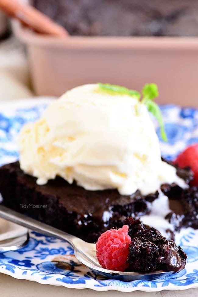 chocolate lava cake on a plate topped with ice cream and raspberries