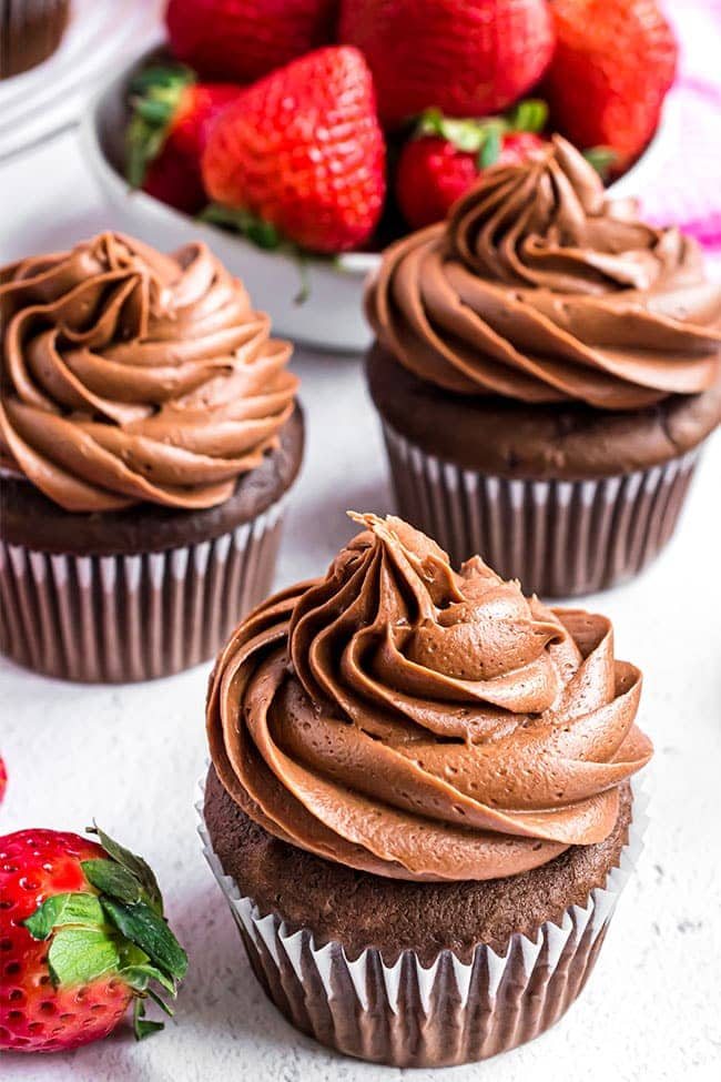 3 chocolate cupcakes with chocolate frosting