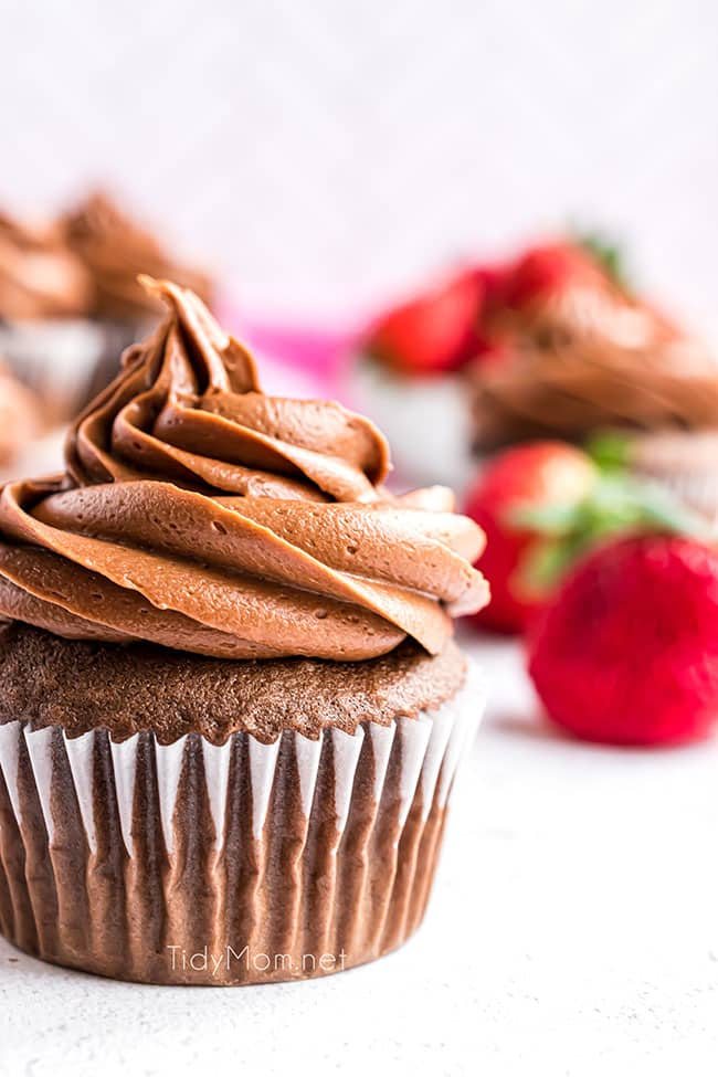 chocolate cupcake with strawberries in background