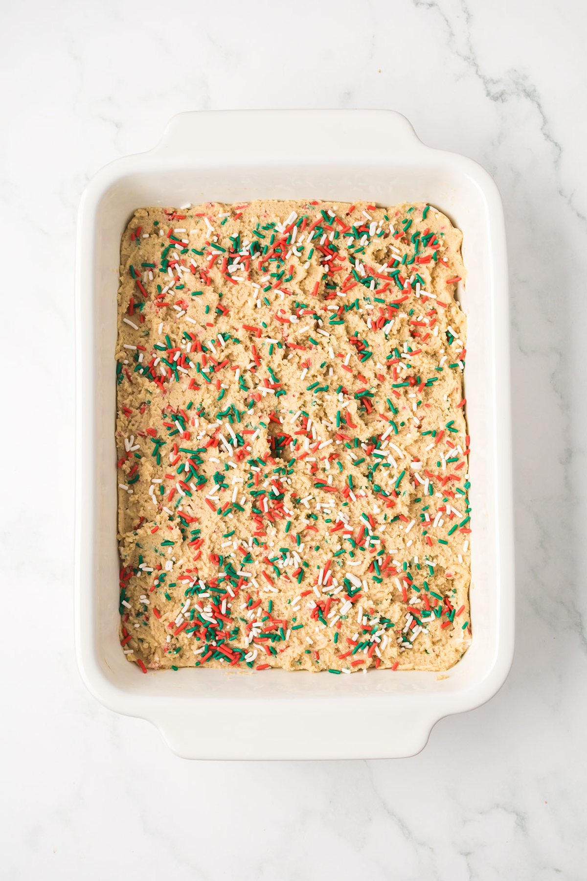 Blondie batter spread evenly in a baking dish before going into the oven.