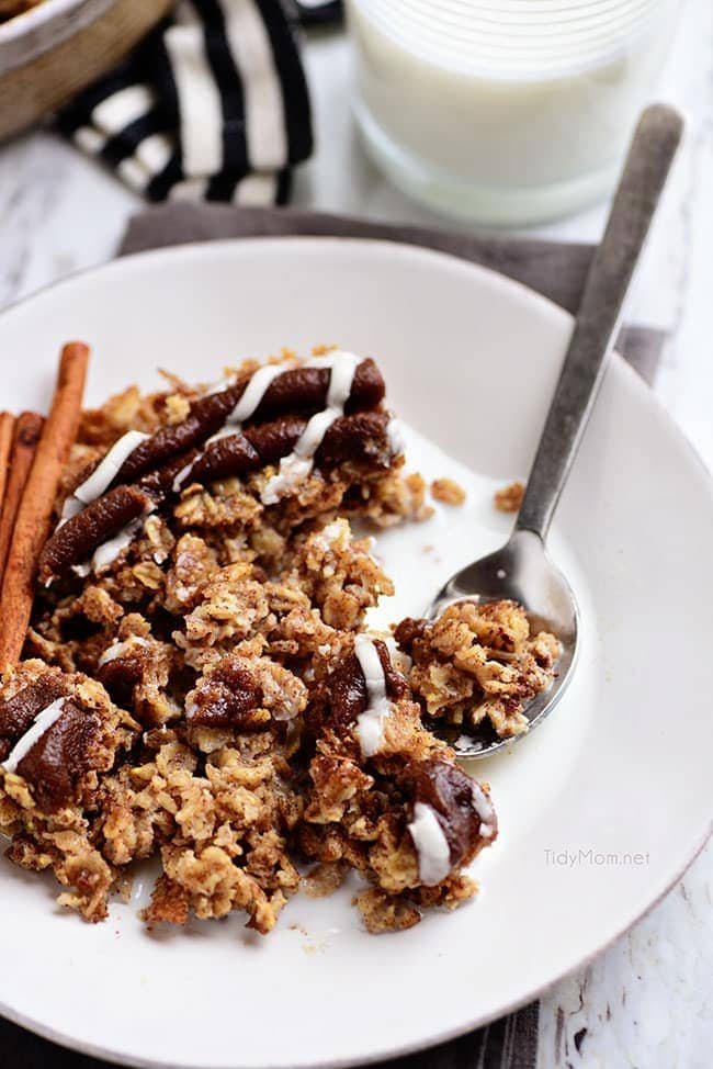 a bowl of Cinnamon Roll Baked Oatmeal with milk and spoon