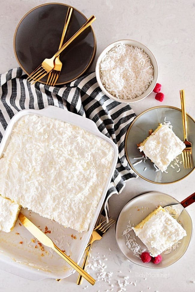 coconut cake in pan with three pieces served on plates