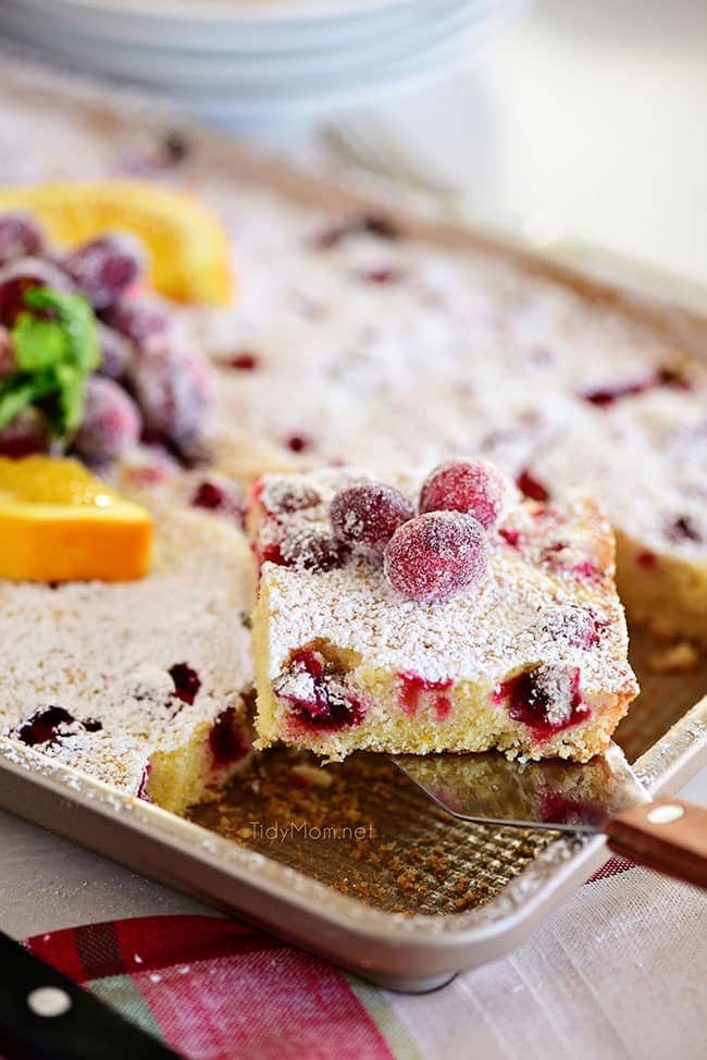 Piece of Super moist Cranberry Orange Cake being removed from pan