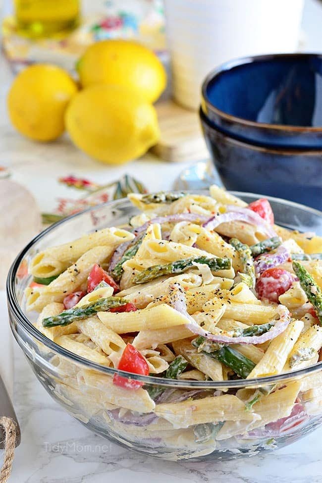 pasta salad in a bowl with lemons in background
