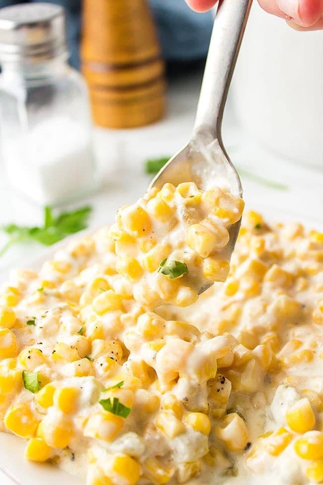 Creamed Corn on a spoon over a plateful.
