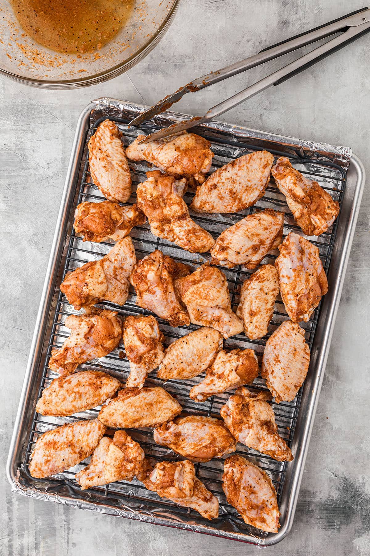 seasoned wings on a baking sheet