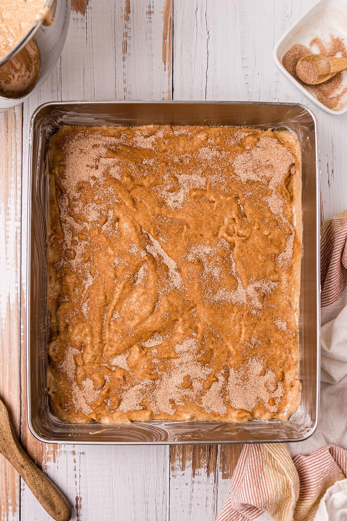 cinnamon and sugar sprinkled over cake batter in a pan
