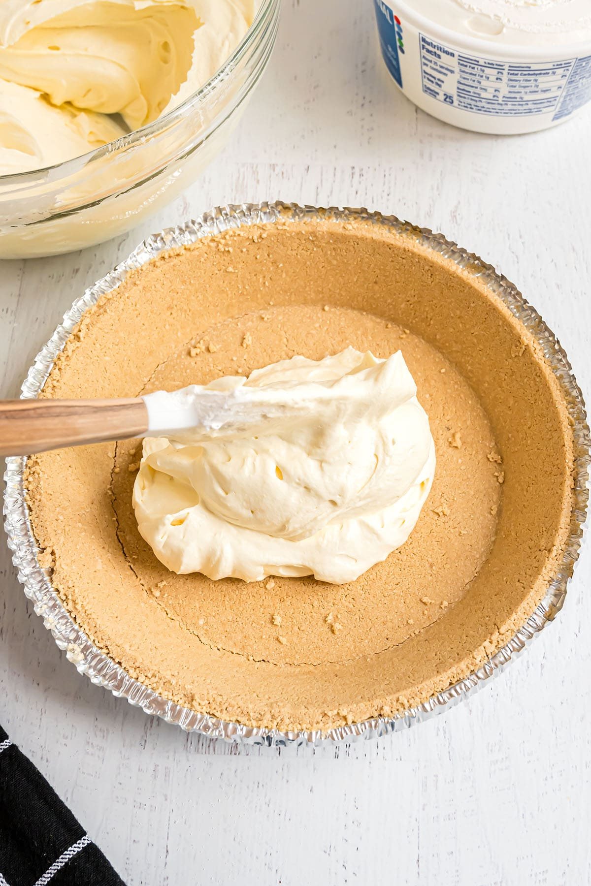 adding prepared instant pudding to a graham cracker pie crust