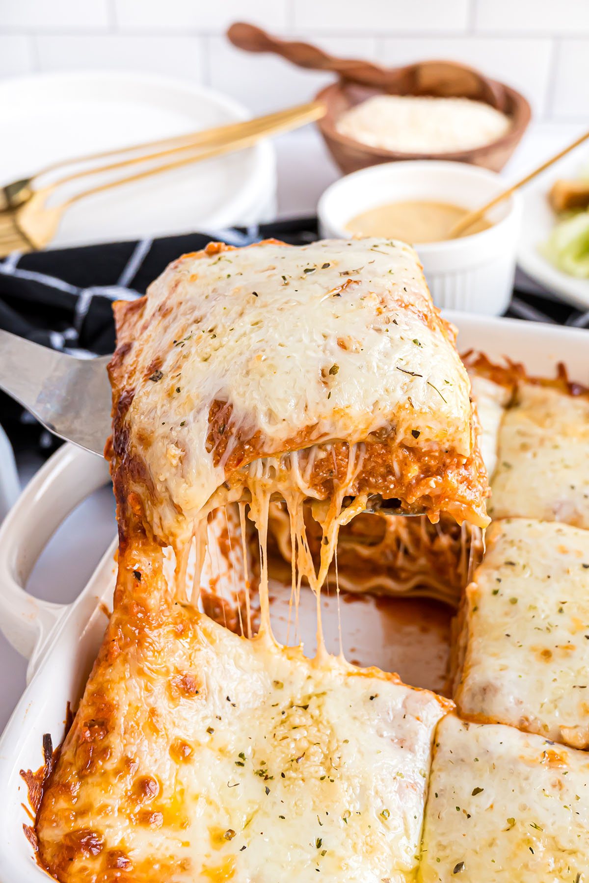 a cheesy serving of lasagna coming out of the baking dish