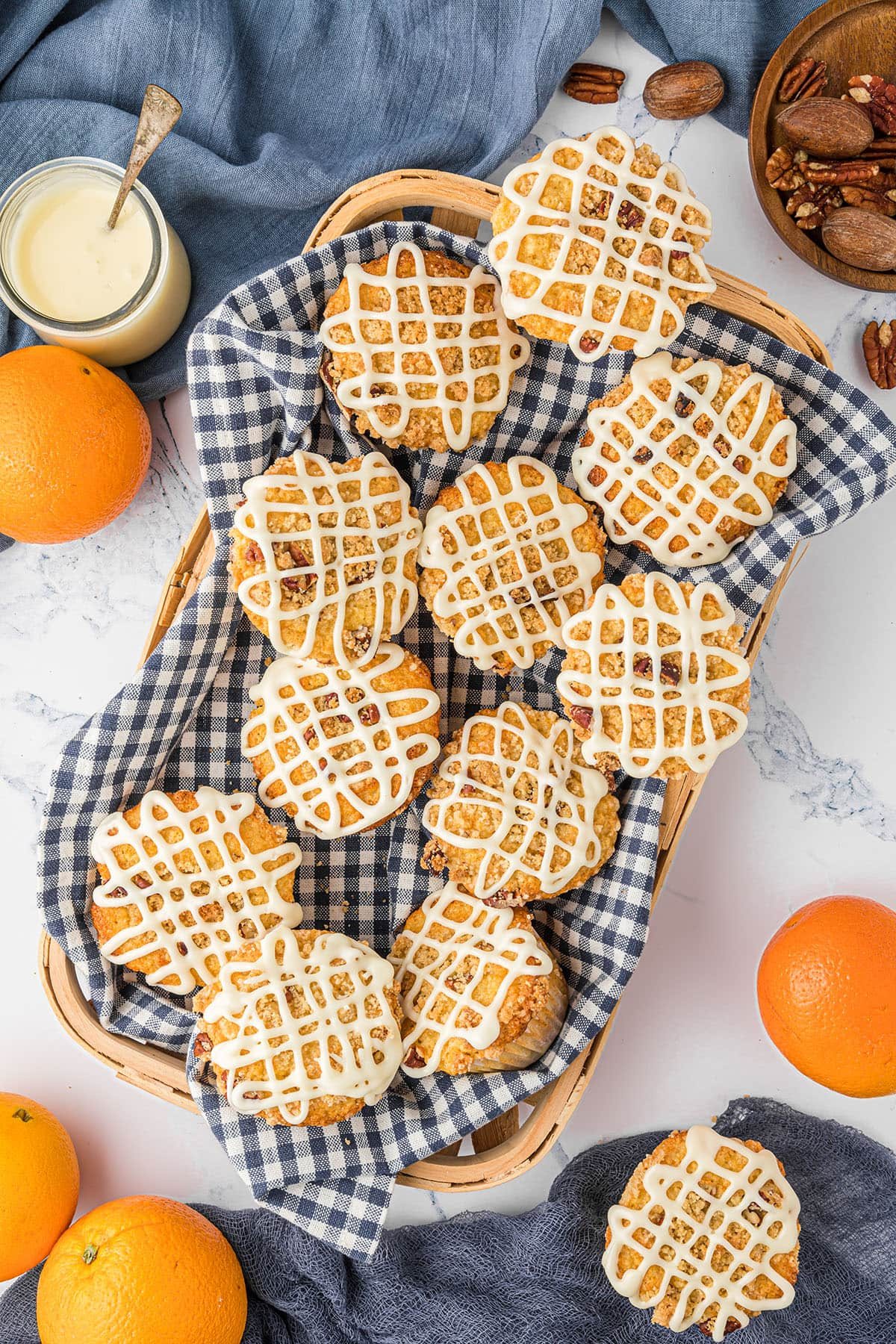 orange muffins in a basket with a blue and white towel